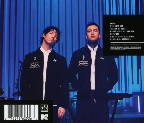Zwei Männer in schwarzen Jacken stehen vor blauem Hintergrund mit Albumcover einer Band.