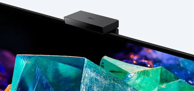 Czarne urządzenie przymocowane do góry telewizora. Wygląda jak kamera.