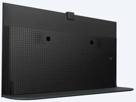 Widok z tyłu czarnego telewizora z teksturowaną powierzchnią. Zawiera stojak. Białe tło.