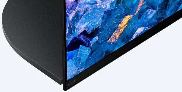 Zbliżenie rogu telewizora z czarną ramą i niebieskim krystalicznym wyświetlaczem.