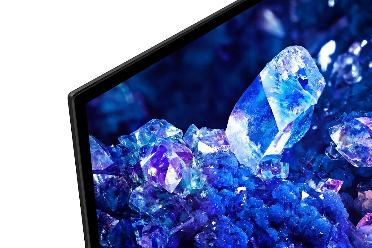 Zbliżenie ekranu telewizora przedstawiające kolorowy, abstrakcyjny obraz z niebieskimi i fioletowymi kryształowymi kształtami.