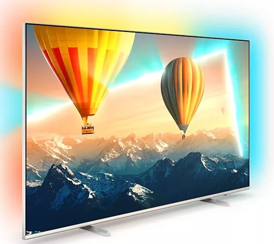 Duży telewizor z balonami na ekranie. Białe tło i kolorowe światła.