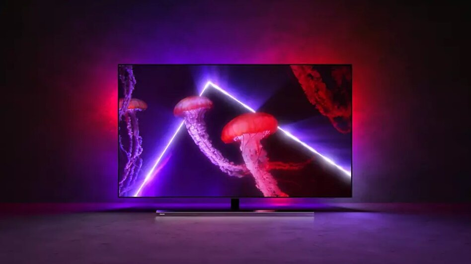Telewizor z czerwonym i fioletowym oświetleniem otoczenia, wyświetlający meduzy.