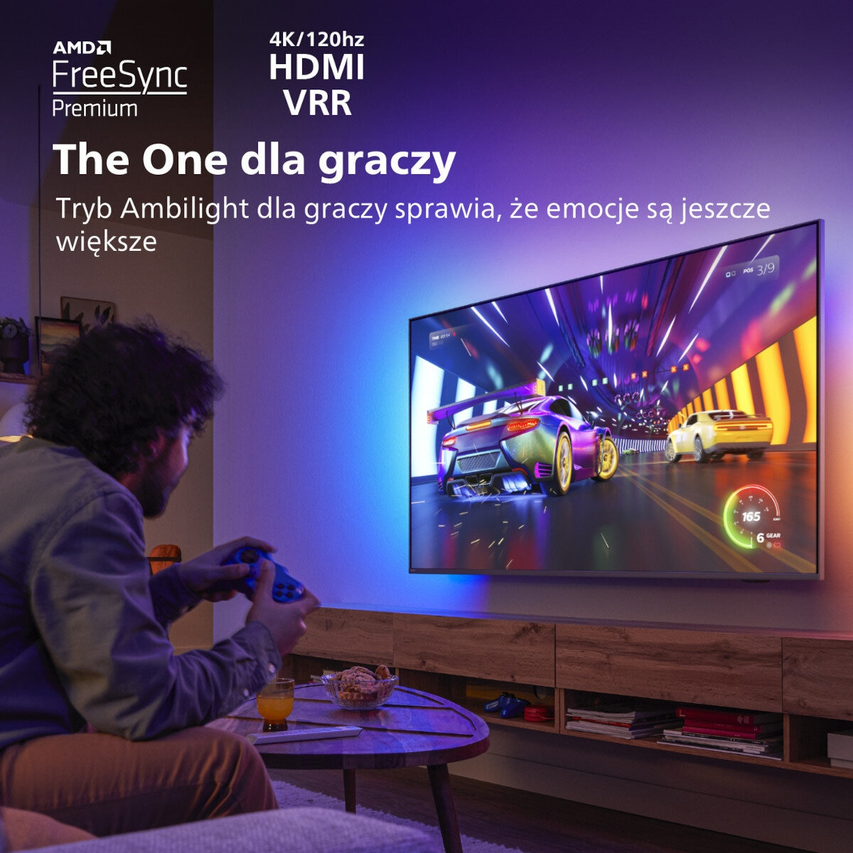 Mężczyzna gra w grę wideo na TV. Wyświetlona gra wyścigowa. Tekst: AMD FreeSync, 4K/120Hz HDMI, VRR.