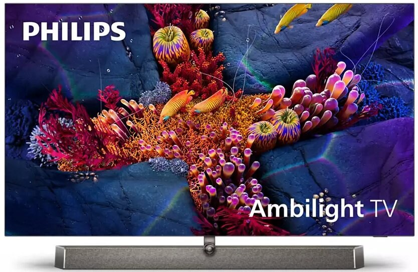 Ekran telewizora wyświetlający podwodną scenę z kolorowymi koralowcami i rybami. Szara podstawa i białe tło.