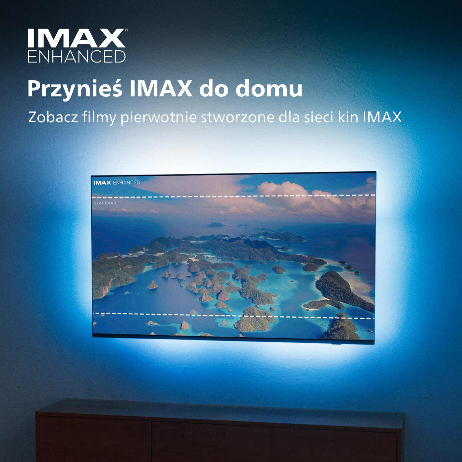 Ekran telewizora z widokiem na ocean zamontowany na ścianie. Telewizor emituje niebieskie światło, otoczony logo IMAX.