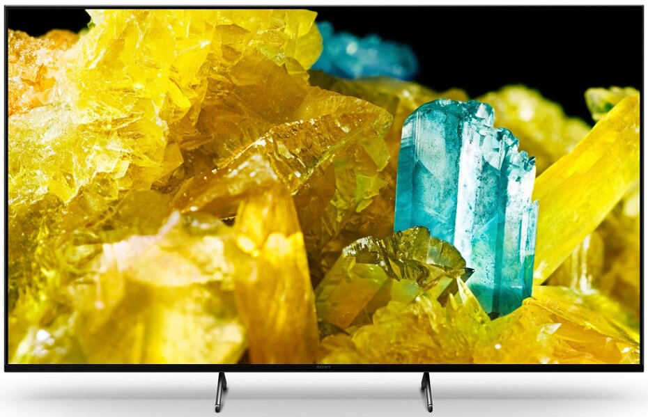 Ekran telewizora wyświetla kolorowe kryształy. Telewizor ma czarną ramkę i stojak.