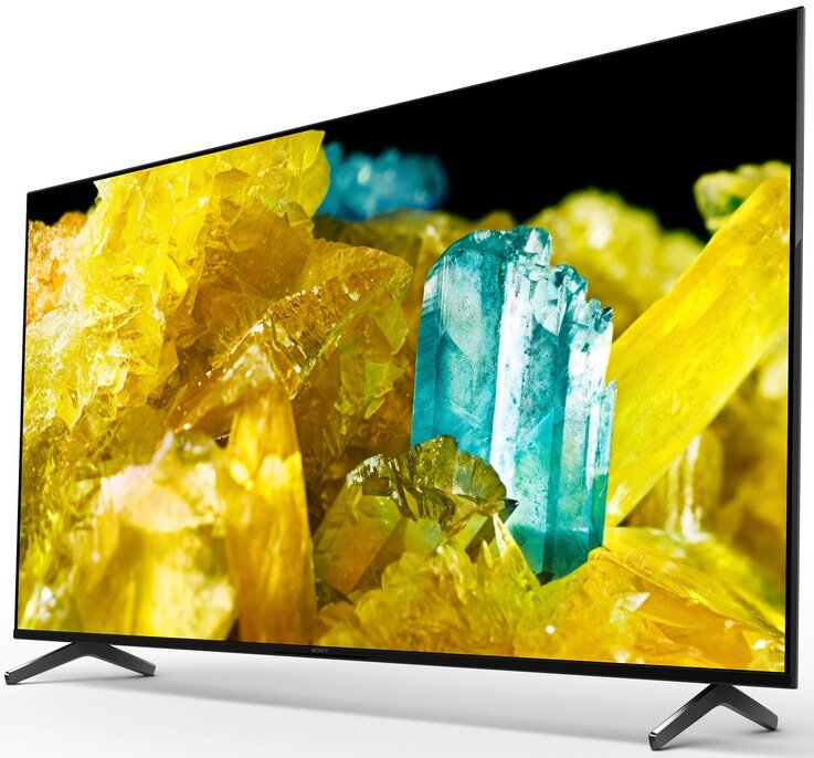 Czarny telewizor wyświetla kolorową abstrakcyjną scenę żółtych i niebieskich struktur krystalicznych.