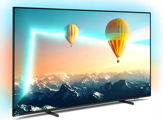 Ekran telewizora pokazujący krajobraz z balonami na ogrzane powietrze i górami.