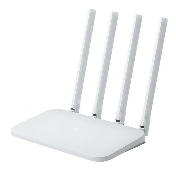 Biały router z czterema antenami stojącymi pionowo. Na białej powierzchni.
