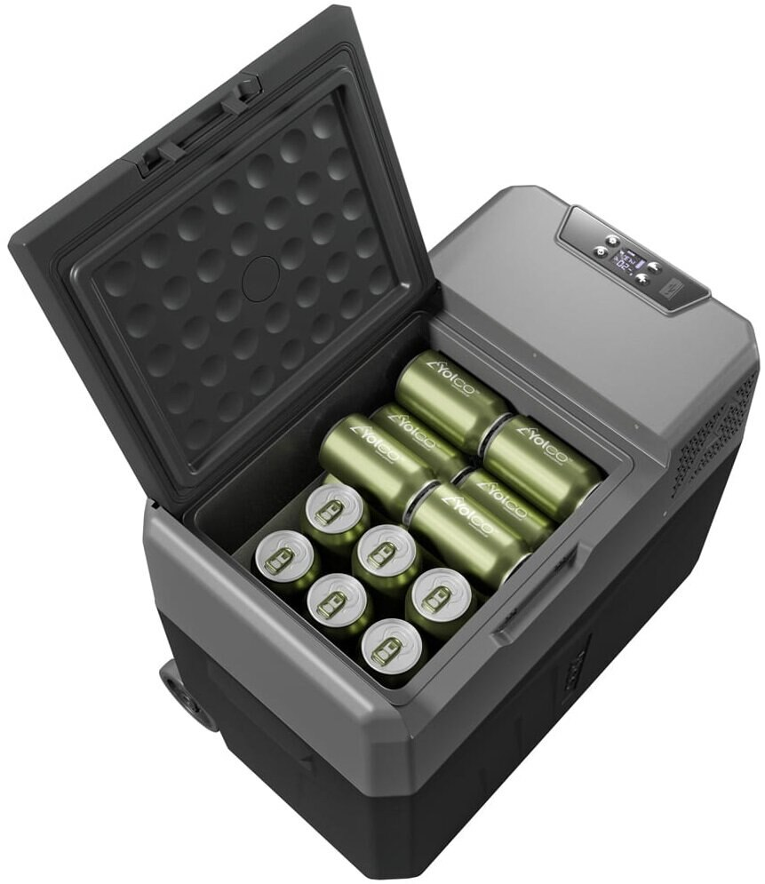 Otwarta przenośna chłodziarka z oliwkowymi puszkami w środku. Chłodziarka jest szara i czarna, pokrywa otwarta. Cyfrowy wyświetlacz na górze.