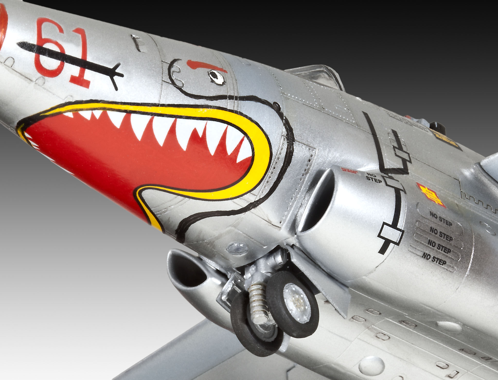 Nahaufnahme eines Spielzeugflugzeugs mit einem Hai-Maul-Design auf der Nase. Das Fahrwerk ist sichtbar.