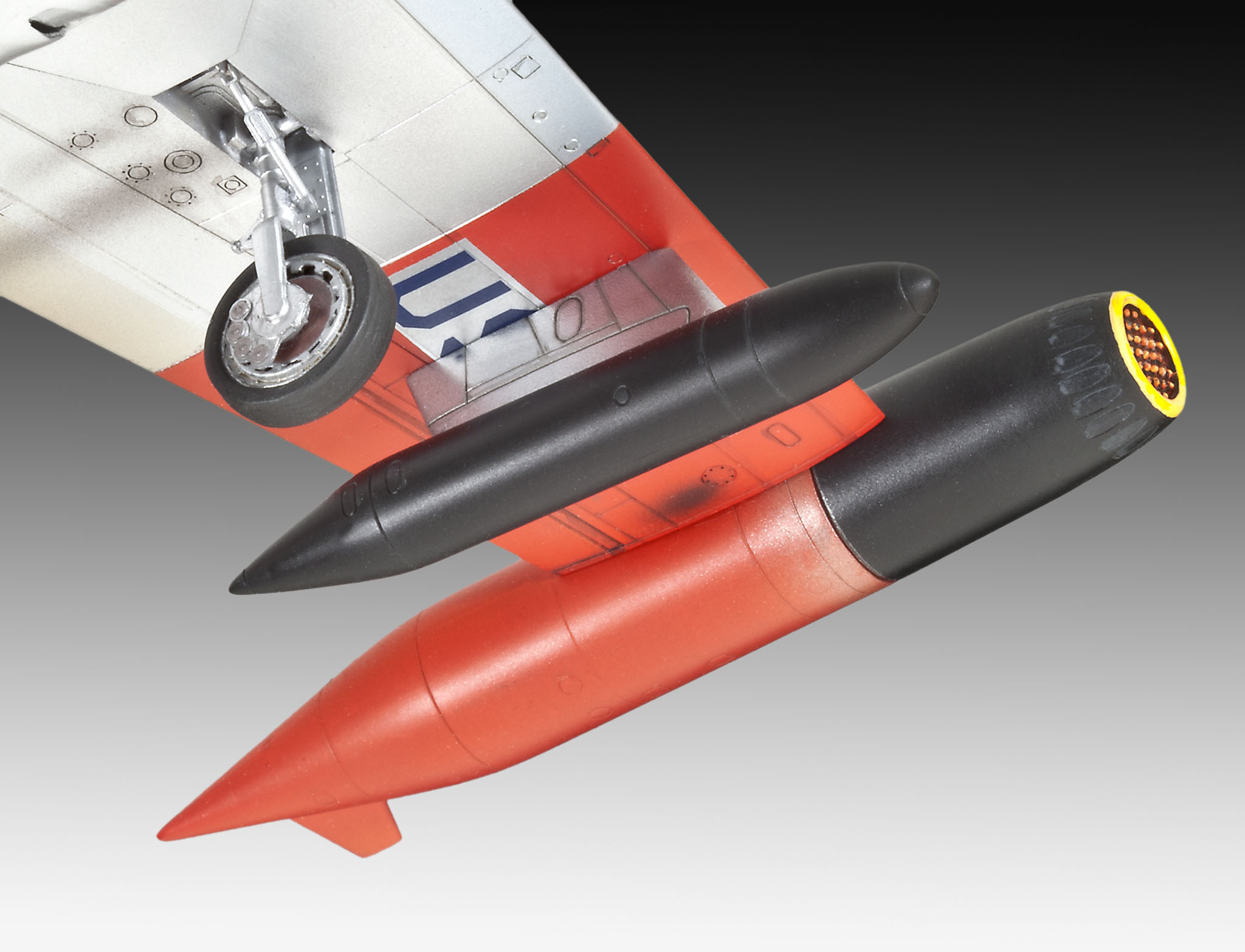 Ein Modellflugzeug, das einen roten Flügel und schwarz-rote raketenartige Strukturen zeigt.