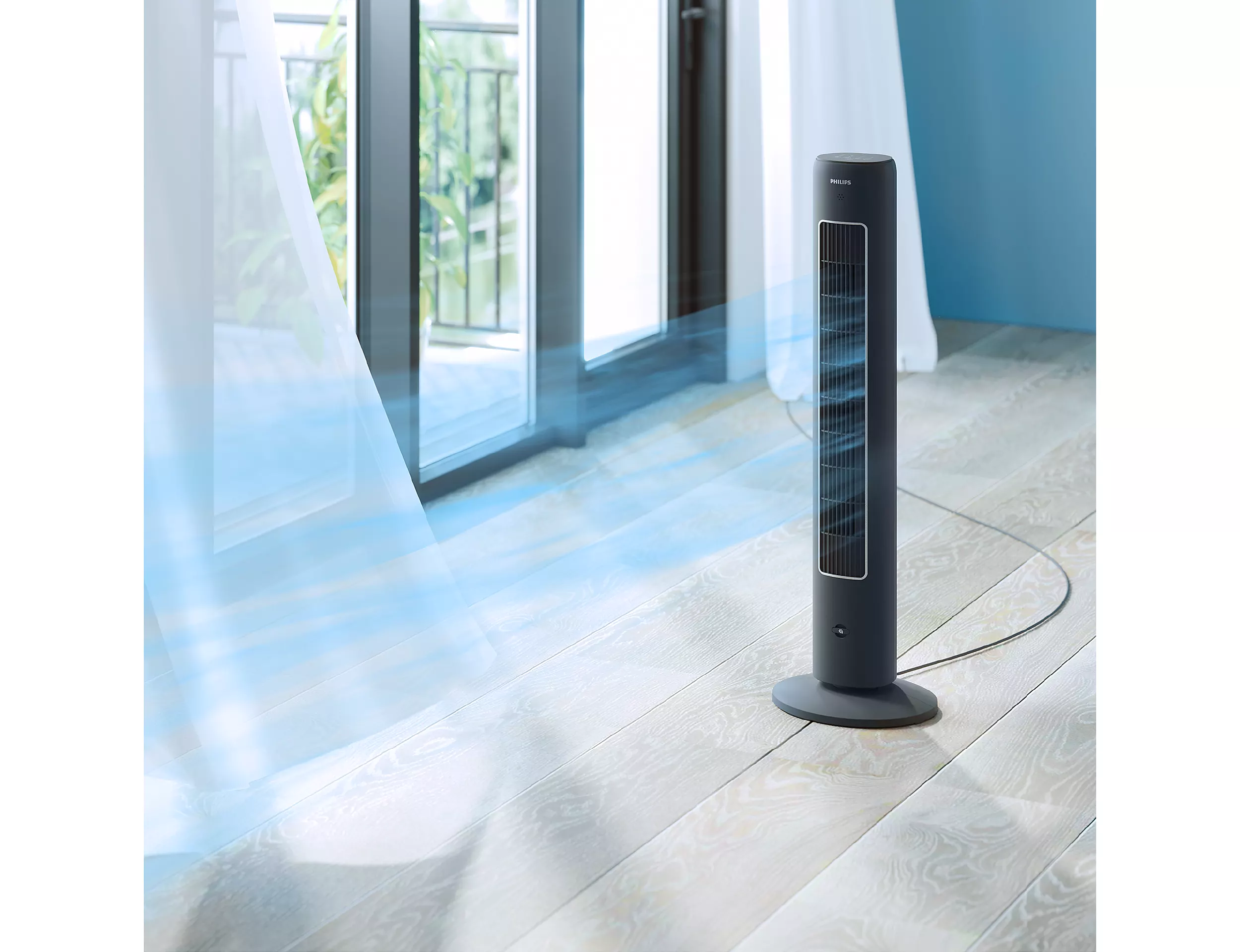 Egy fekete torony ventilátor egy fa padlón, egy ablakkal és függönyökkel a háttérben.