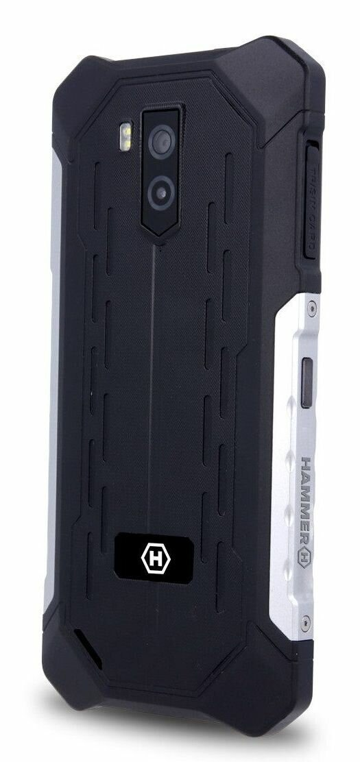 Czarny, wytrzymały tył smartfona. Zawiera aparat i lampę błyskową. Srebrne akcenty po bokach. Telefon ma logo Hammer.