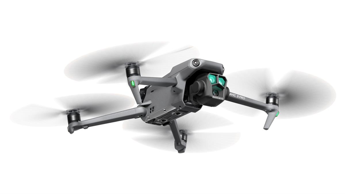 Dönen pervanelere sahip gri bir drone, beyaz zemin üzerinde.