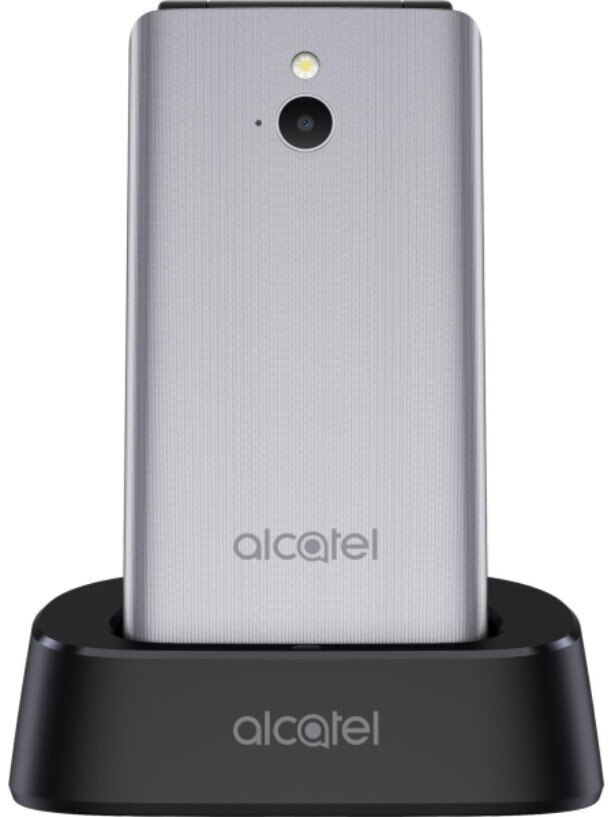 Srebrny telefon z klapką w czarnej stacji ładującej. Widoczne logo Alcatel. Widoczna kamera i lampa błyskowa.