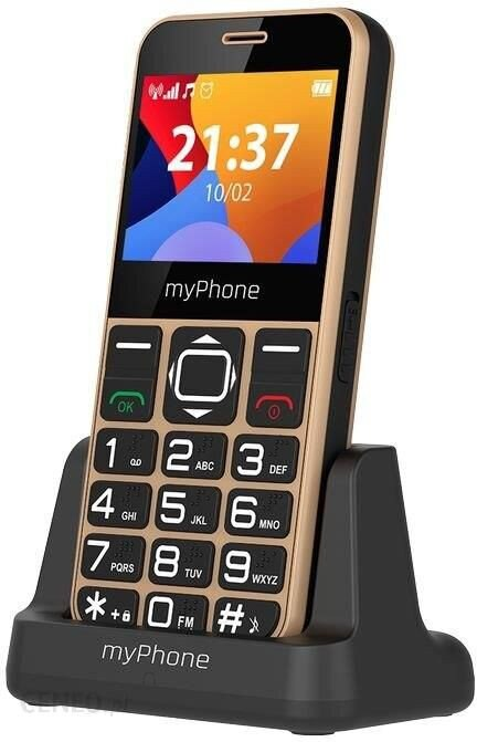Złoty myPhone na czarnym stojaku pokazuje godzinę 21:37. Posiada duże przyciski ułatwiające użytkowanie. Ekran wyświetla kolorowe ikony.