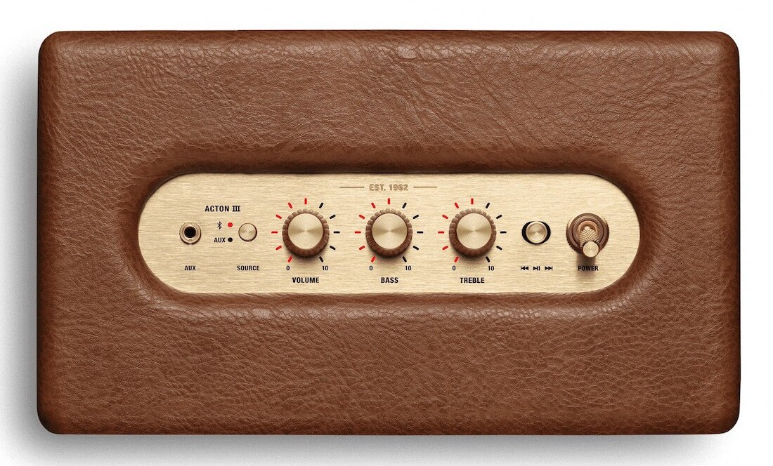 Brązowy głośnik ze złotymi elementami sterującymi. Ma pokrętła głośności, basów i tonów wysokich oraz przycisk zasilania.