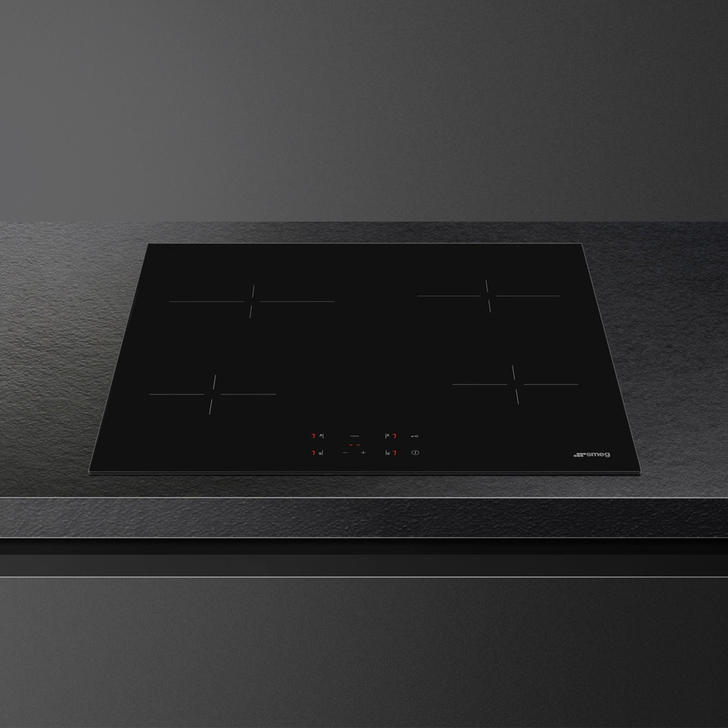 Piano cottura a induzione nero con quattro fuochi. Design elegante, vista dall'alto, su superficie nera.