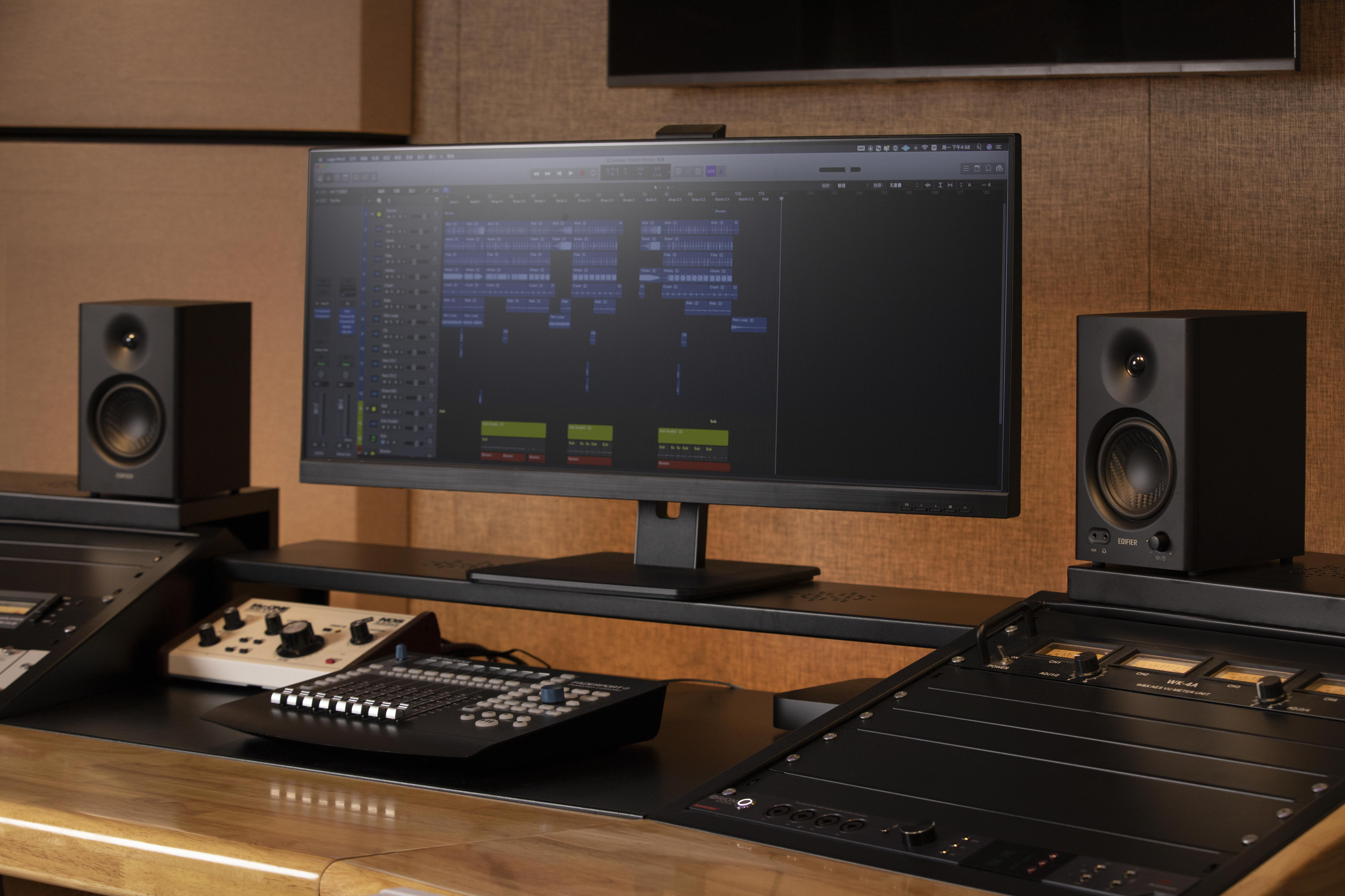 Ein Tonstudio-Setup mit Lautsprechern, einem Monitor und Mischpult.