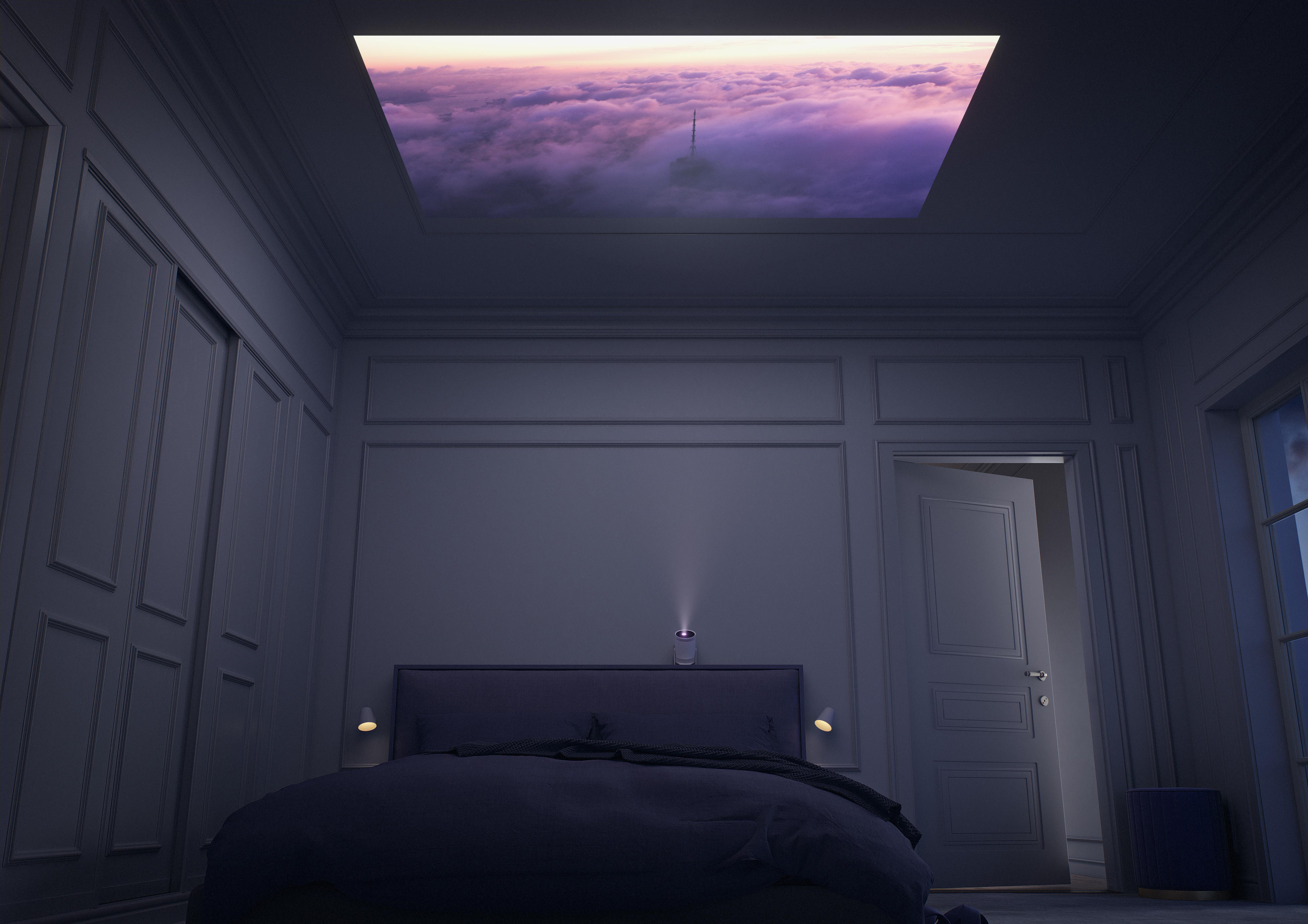 Schlafzimmer-Szene, Projektor an. Wolkenbild an der Decke. Bett und Tür sichtbar. Dunkle Atmosphäre.