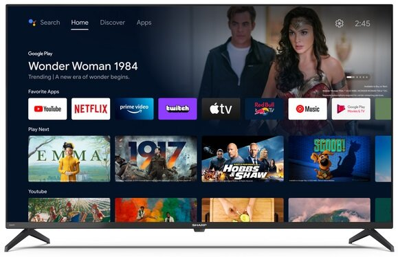 Duży ekran telewizora wyświetlający aplikacje filmowe i plakat filmu Wonder Woman 1984.