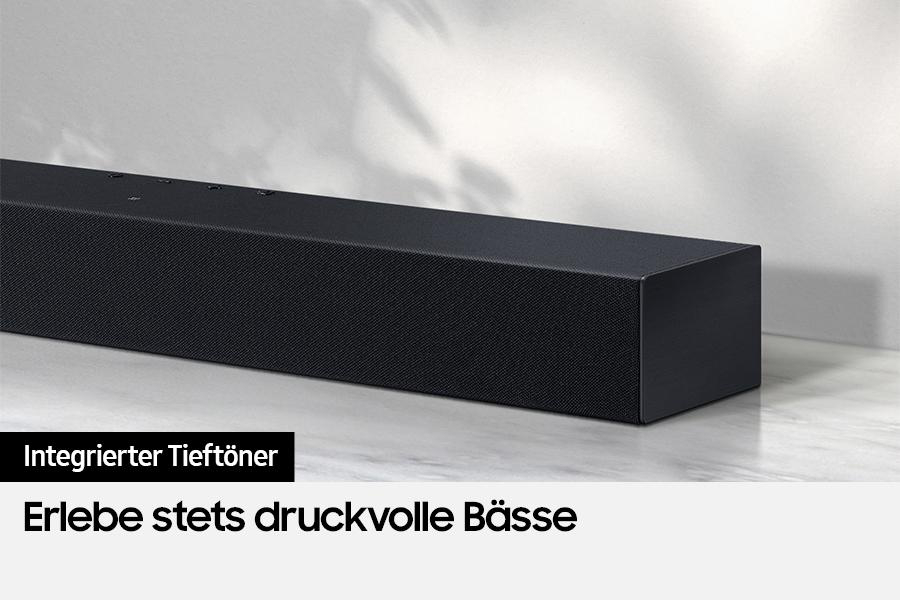 Schwarze Soundbar mit Text: 'Erlebe stets druckvolle Bässe'.