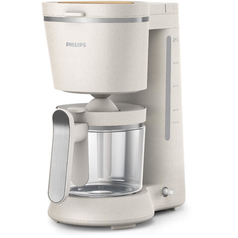 A cream-colored coffee maker with a glass carafe and a water level indicator.