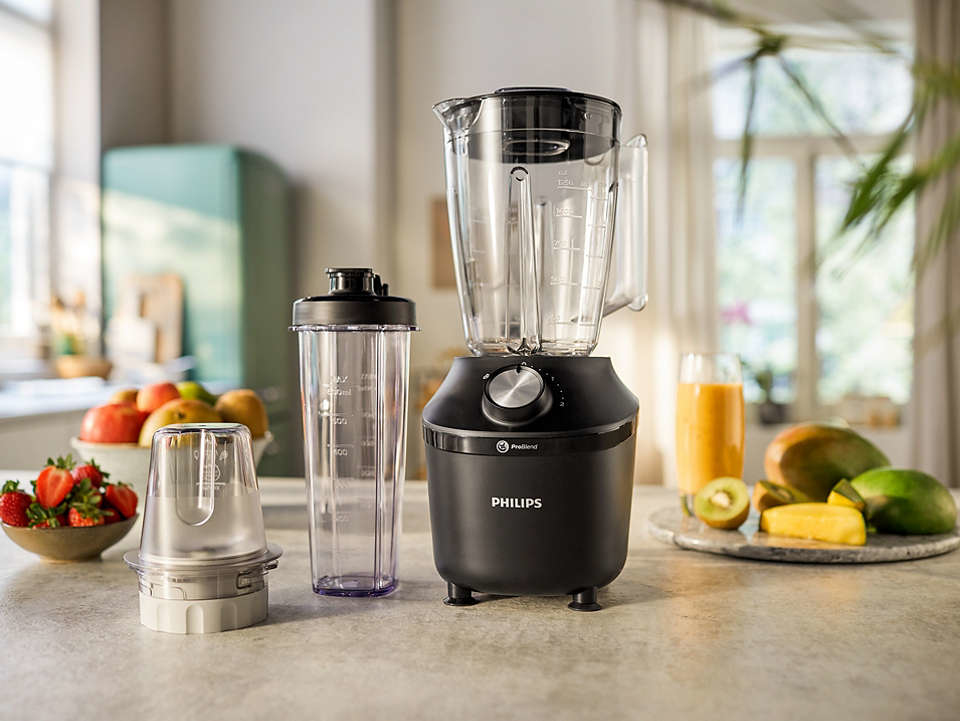 A black blender with a clear pitcher, a smaller container, and fruit on a countertop.