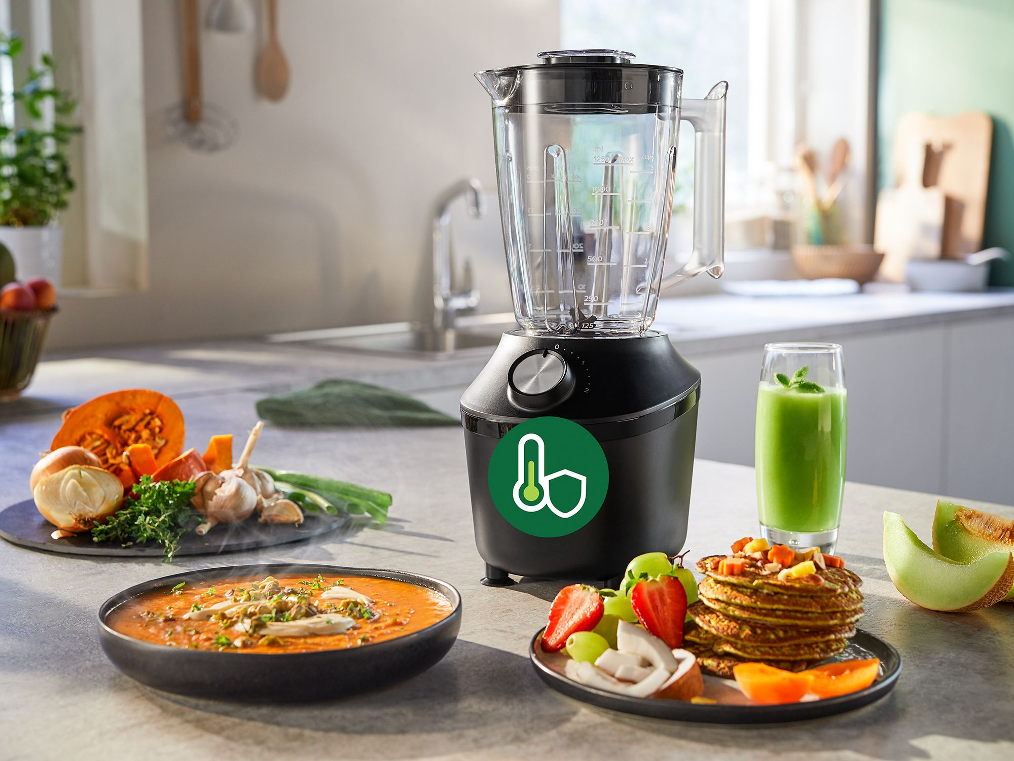 A blender with food items: soup, pancakes, fruit, and a glass of green smoothie.