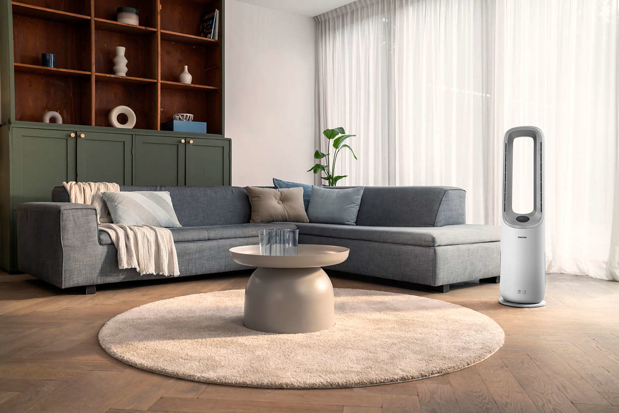 Living room with sofa, coffee table, and a fan.
