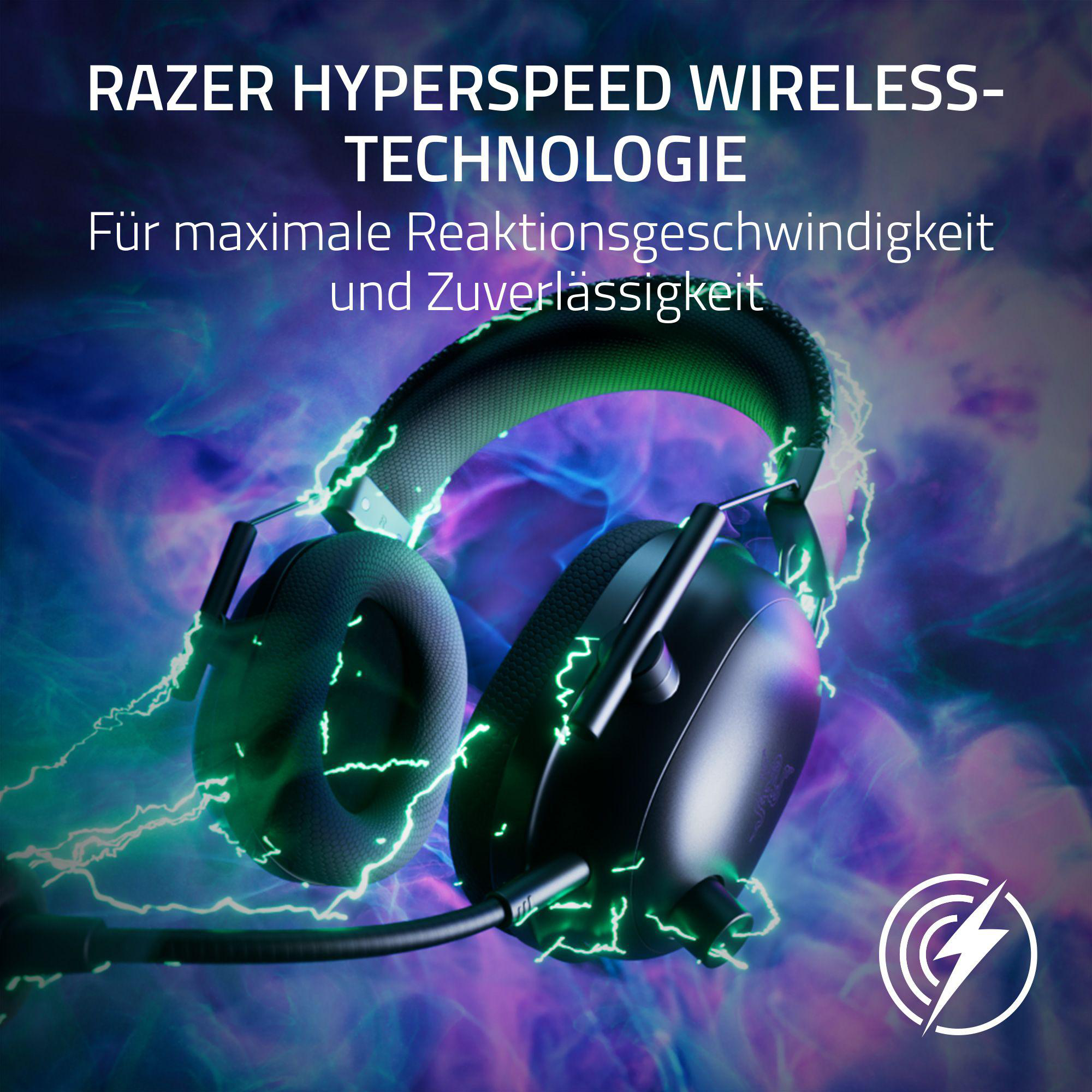 Schwarze Gaming-Kopfhörer mit grünen Lichteffekten und Razer-Logo auf violettem Grund.