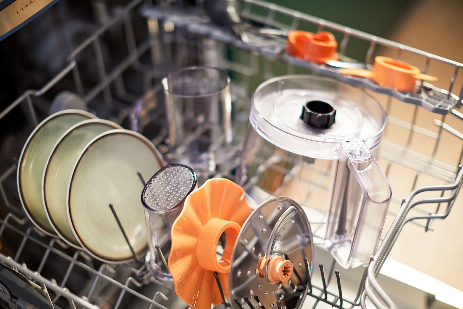 Dishwasher with plates, cups, and other parts inside.