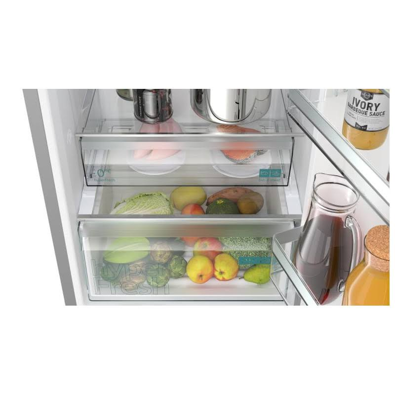 Interior de nevera con productos y salsas. Estantes con frutas, verduras y botes de salsa.