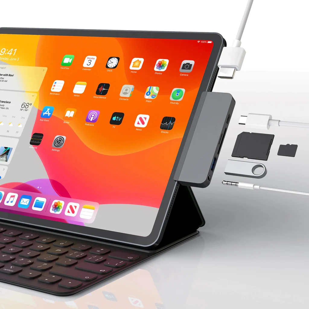 Tableta con teclado y accesorios conectados. Varios puertos y cables visibles.