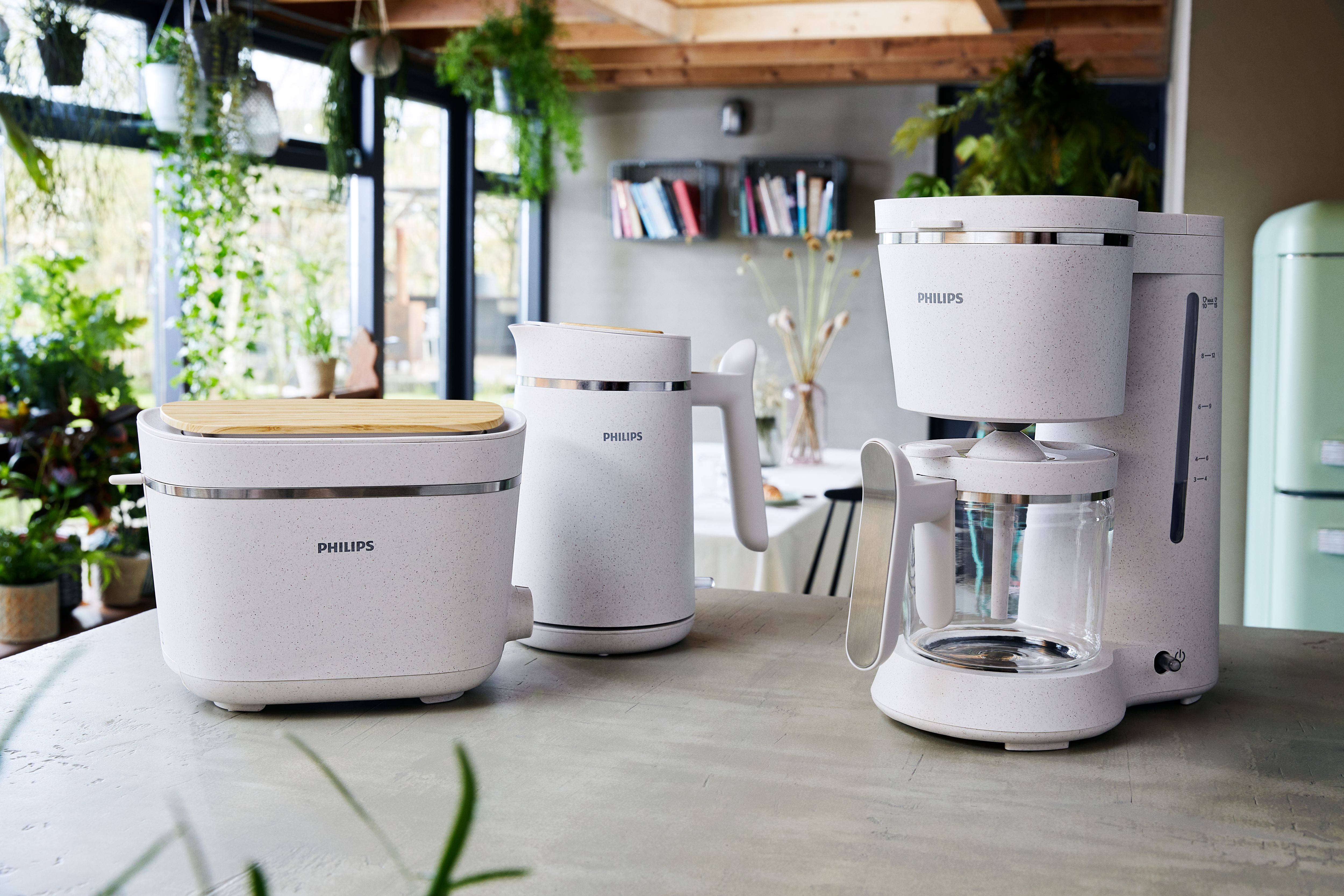 Kitchen countertop with white Philips appliances: toaster, kettle, and coffee maker.