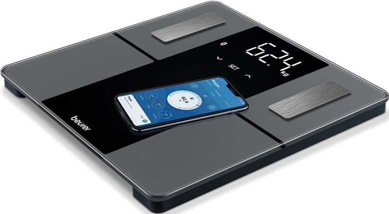 Bilancia digitale con telefono che mostra dati e lettura di 62,4 kg.