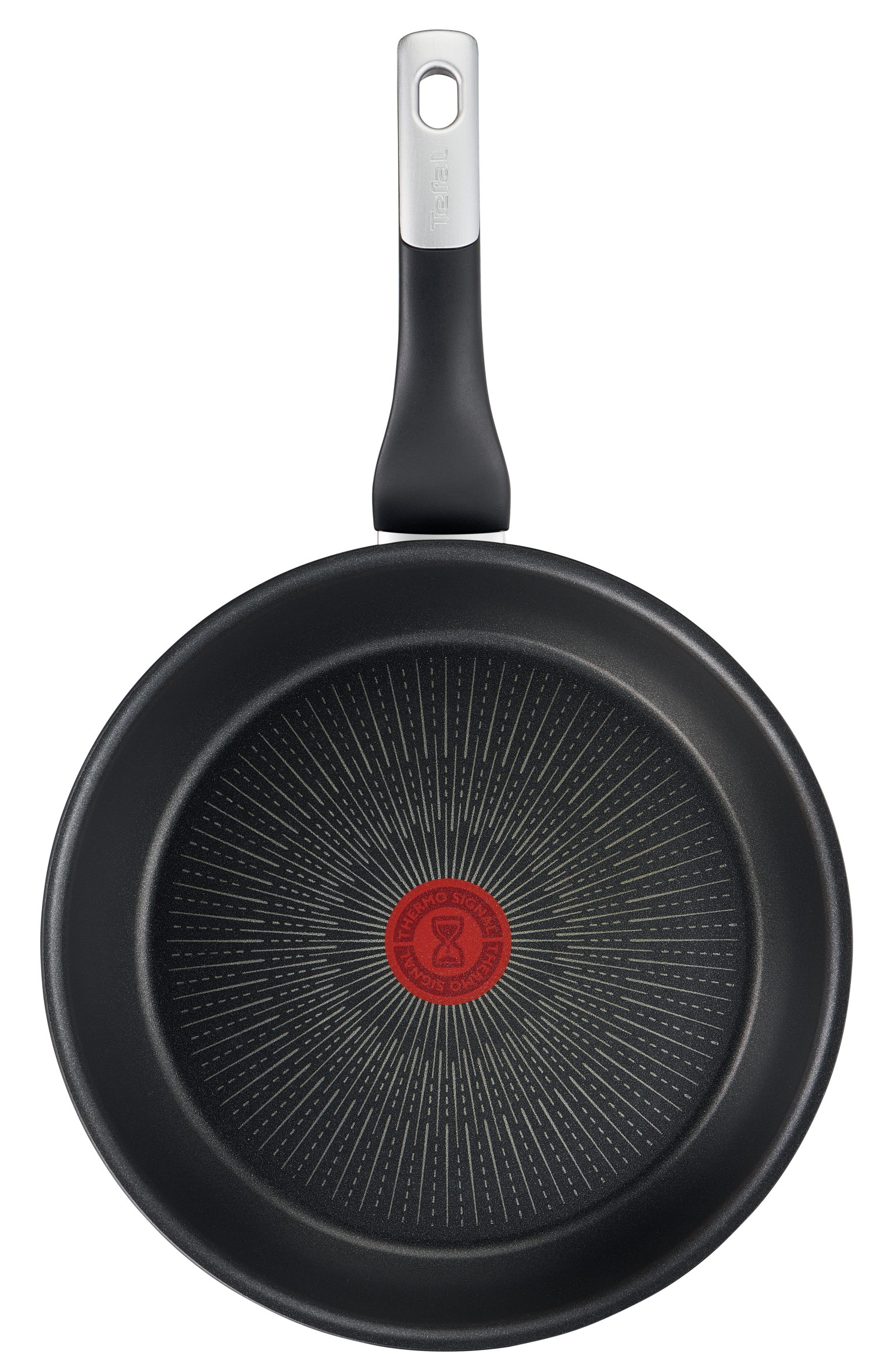 Sartén negra, vista inferior. Círculos concéntricos, logo rojo en el centro. Mango negro arriba.