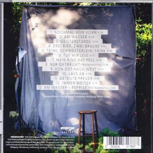 Rückseite einer CD. Weißer Text auf dunkelblauem Hintergrund. Ein Holzschemel im Vordergrund.