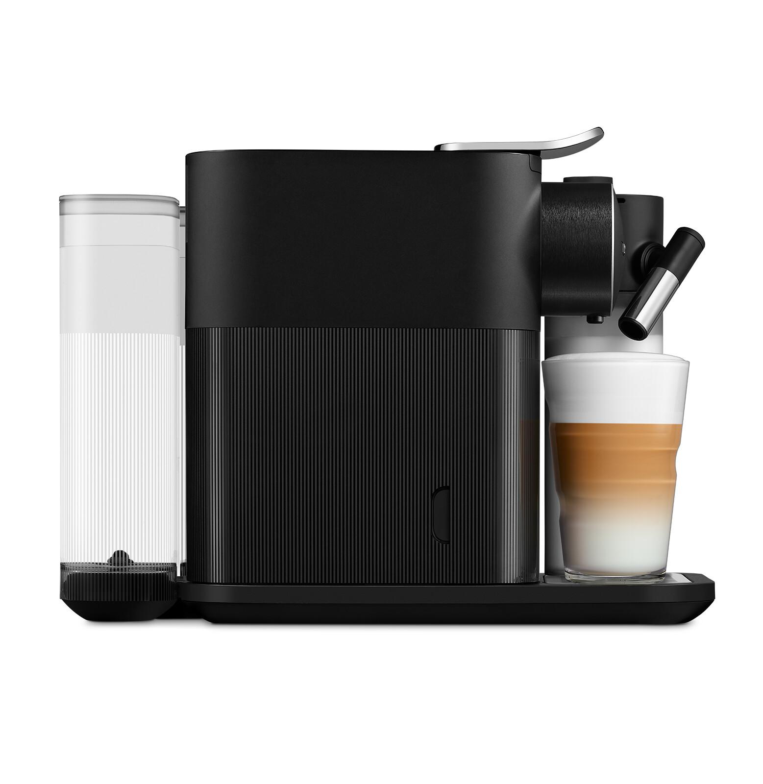 Schwarze Kaffeemaschine mit Wassertank und Glas. Im Glas rechts ist ein Latte.