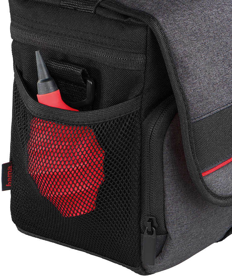 Black and gray camera bag. Red air blower in a side mesh pocket. Hama logo visible.