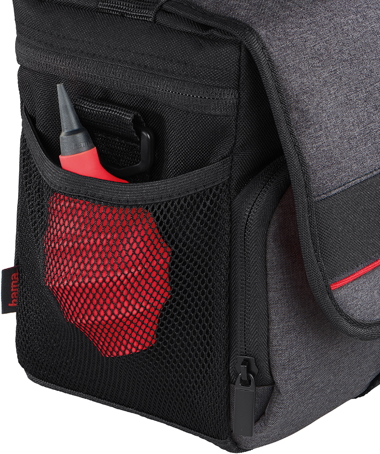 Black camera bag with red air blower in mesh pocket.