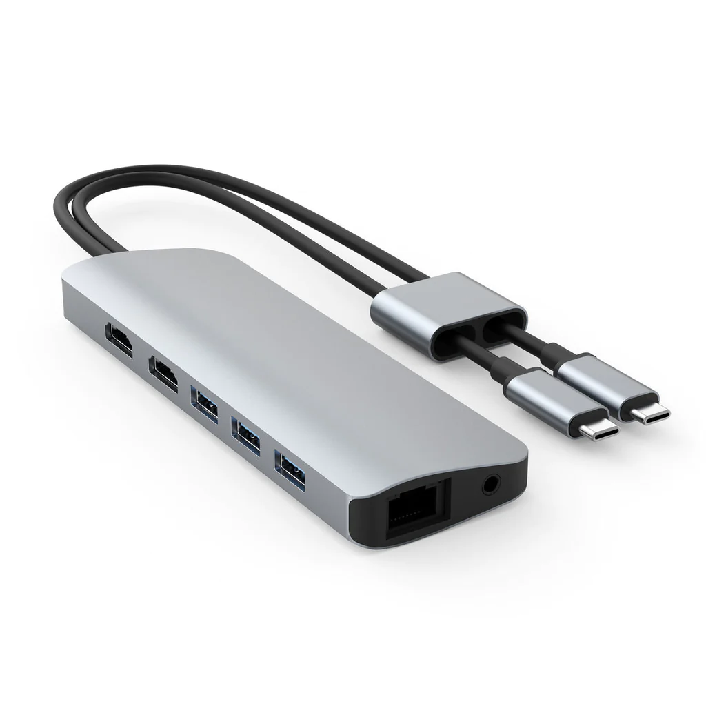 Concentrador USB plateado con múltiples puertos y dos cables USB-C.