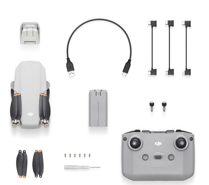 Elementy drona rozłożone: dron, pilot, śmigła, bateria, kable i etui. Białe tło.