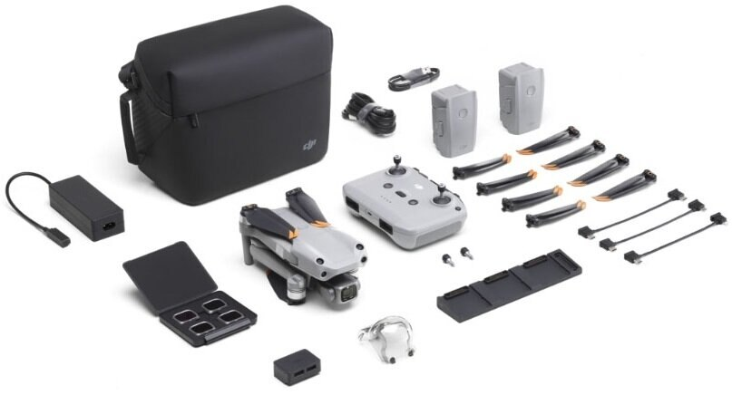 Zestaw drona z dronem, pilotem, bateriami, śmigłami, ładowarką, kablami i etui. Na białej powierzchni.