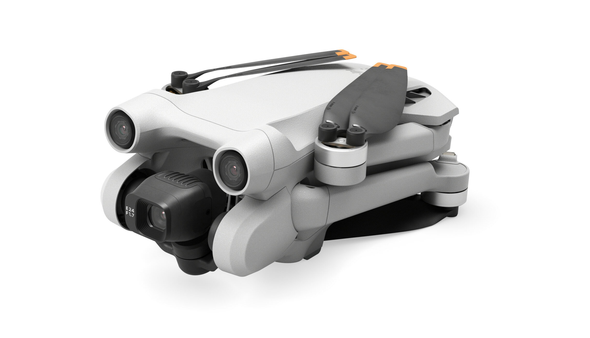 Biało-szary dron ze złożonymi ramionami i śmigłami. Dron znajduje się na białej powierzchni.