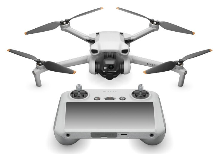 Biały dron i pilot. Dron ma cztery śmigła i aparat.