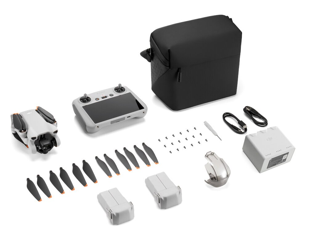 Zestaw drona z dronem, pilotem, bateriami, ładowarką, śmigłami i torbą transportową na białym tle.