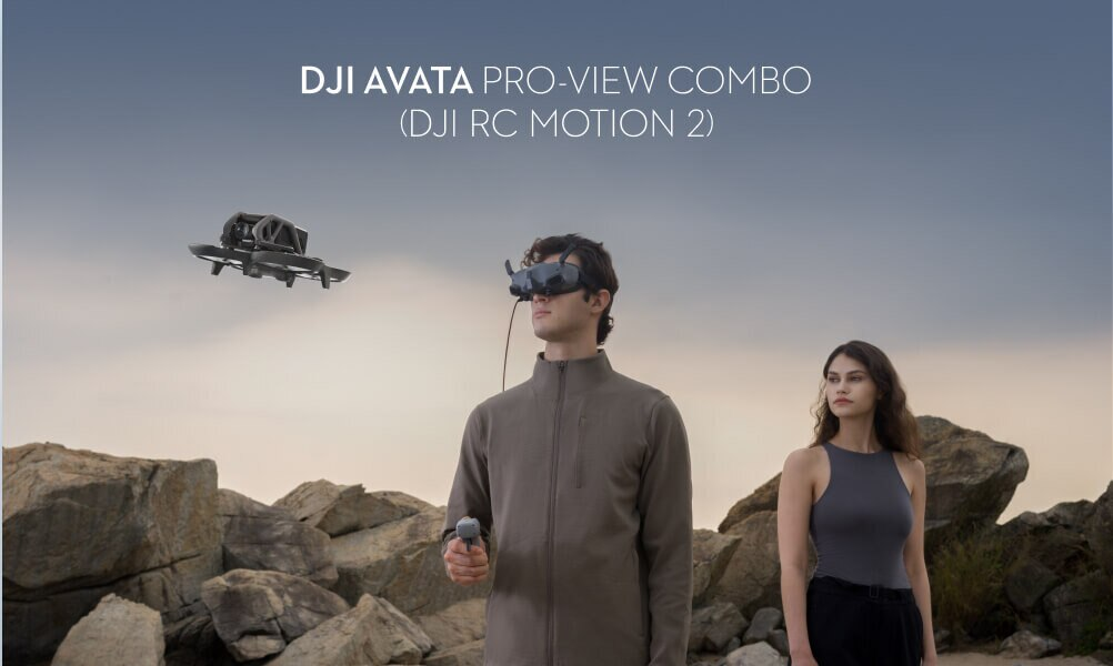 Osoba nosząca gogle VR z dronem latającym nad nią. W pobliżu stoi kolejna osoba.